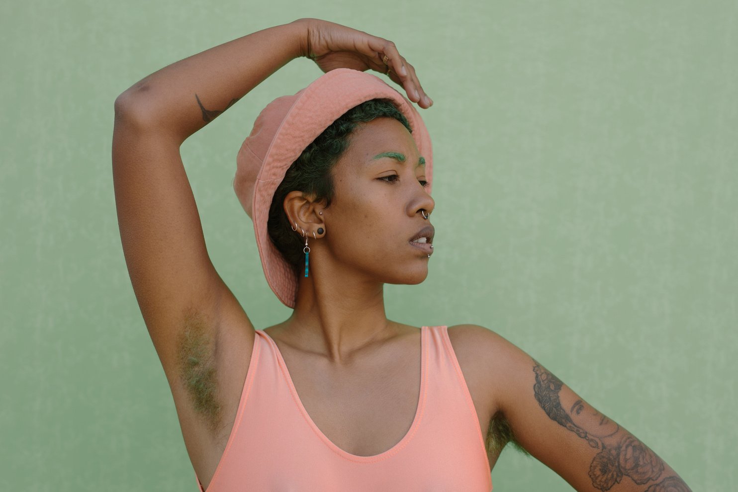 Woman in Pink Suit and Hat with Hair on Armpit